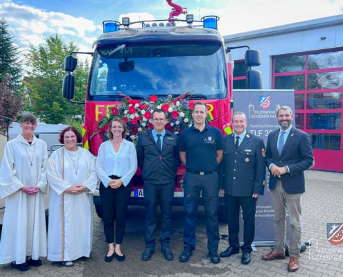 Gruppenbilder vor dem neuen Fahrzeug, die Gottesdienstbeauftragten, die Bürgermeisterin, die beiden Kommandanten, der Kreisbrandrat und der Landrat