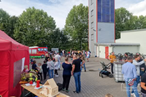 Besucher auf dem Hof der Feuerwehr, mit Hüpfburg, Rauchzelt