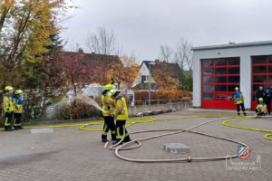 Die Aufgabe wird ausgeführt. Schläuche liegen auf dem Hof der Feuerwehr