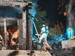 Feuerwehrläute neben abgebrannter Gartenhütte