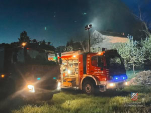Zwei Feuerwehrfahrzeuge auf einer Wiese.